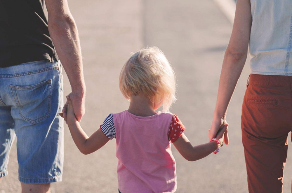 young girl walking with her parents